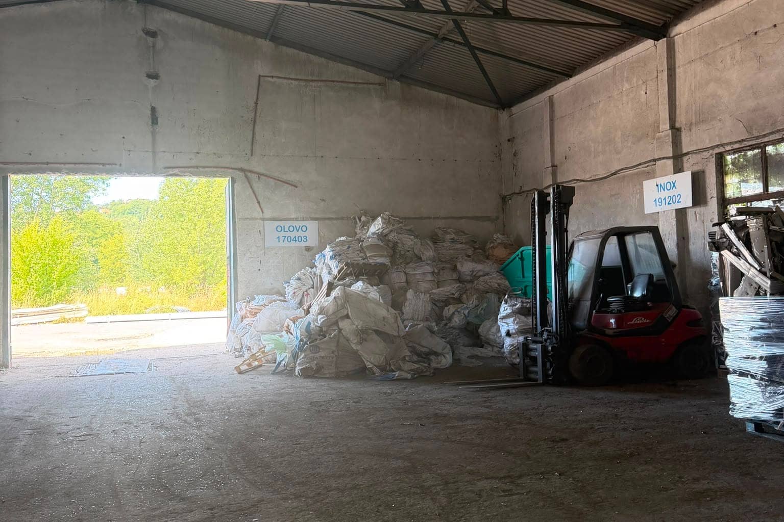 Boksovi u hali označeni tablama OLOVO 170403 i INOX 191202, sa viljuškarom i velikim vrećama